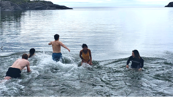 Cinq participants du pont océanique nageant dans les eaux froides du lac Supérieur.